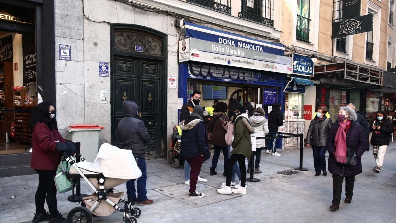 Varias personas hacen cola ante la administración de lotería Doña Manolita, en Madrid, a 5 de enero de 2021
