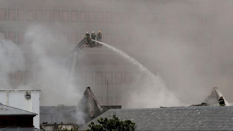 Bomberos trabajan en el incendio que afecta al Parlamento de Sudáfrica, en Ciudad del Cabo, este domingo 2 de enero de 2022.