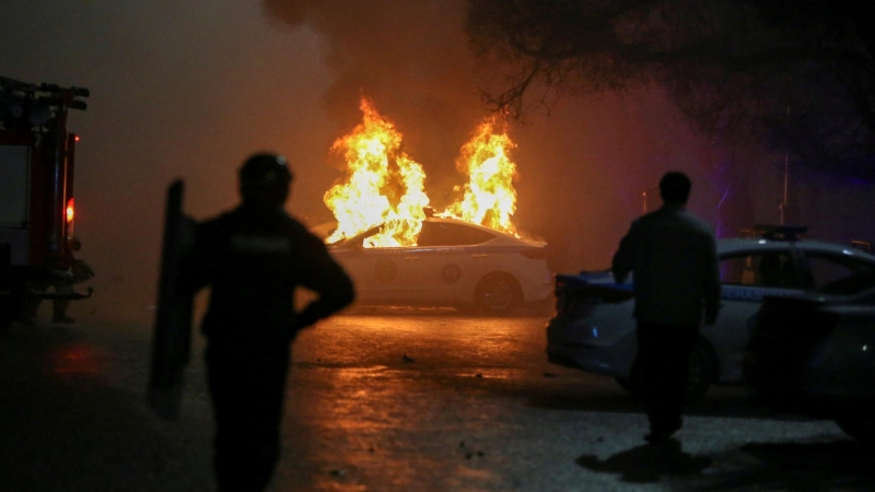 05/01/2022 un coche de policía en llamas durante las protestas en Almaty, Kazajstán