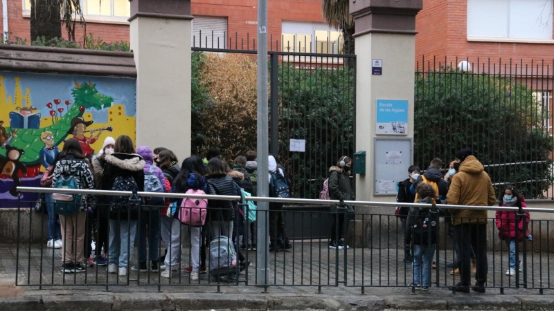 Pla general de l'Escola de les Aigües, amb pares i mares esperant alumnes.