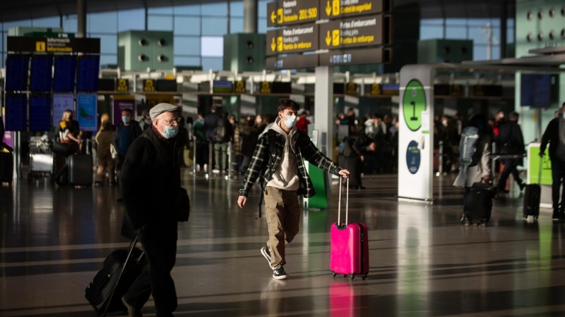Varios pasajeros con maletas en el aeropuerto de El Prat, en Barcelona. E.P./David Zorrakino