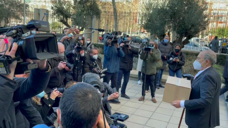Carlos San Juan con su caja de firmas en el exterior del Ministerio de Economía, y rodeado de periodistas.