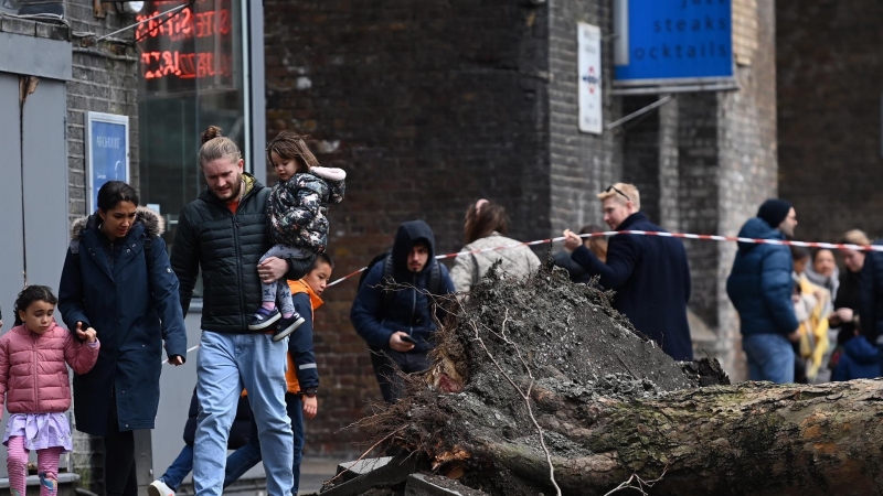 La gente pasa junto a un árbol caído derribado por fuertes vientos durante la tormenta Eunice en Londres, Gran Bretaña, el 18 de febrero de 2022.