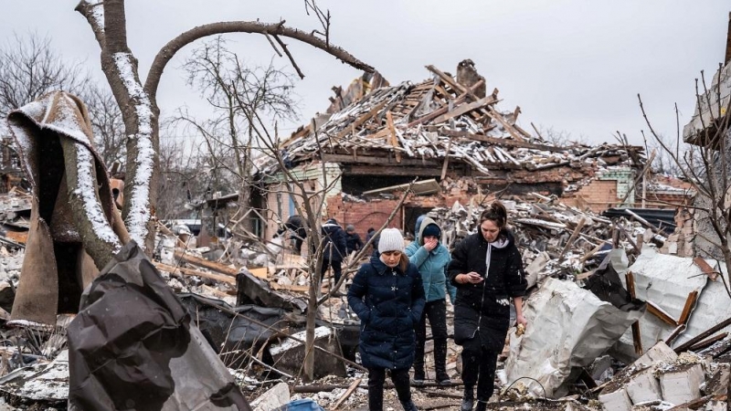 03/03/2022. Mujeres ucranianas caminando sobre los restos de edificio residencial destruido.