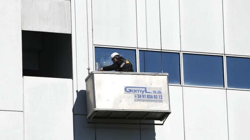Un trabajador limpia los cristales de un edificio, en Madrid, a 21 de febrero de 2020.