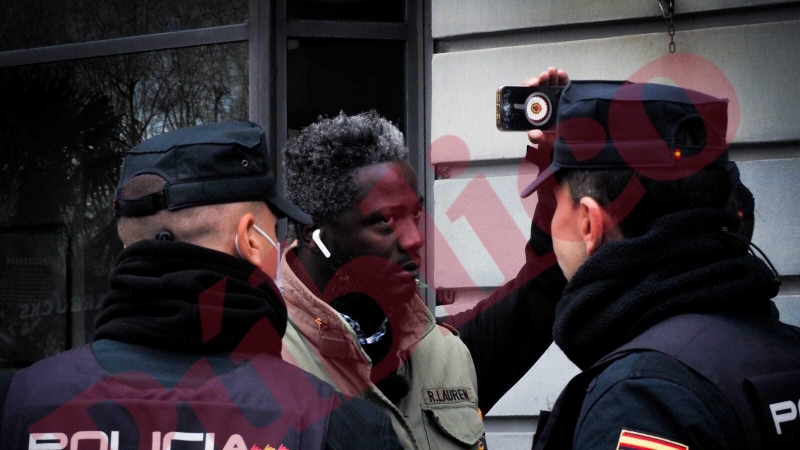El militante de Vox Bertrand Ndongo y extrabajador del equipo de Rocío Monasterio tras un cordón de policías tras increpado en la manifestación estudiantil feminista con motivo del 8M en la Puerta del Sol de Madrid este 8 de marzo de 2022.