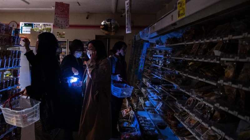 La gente compra en una tienda en una zona residencial durante un corte de energía en el distrito de Koto en Tokio