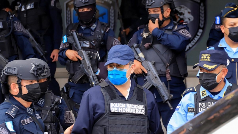 El expresidente de Honduras Juan Orlando Hernández, en el centro de la imagen, con mascarilla azul, en el momento de ser detenido el 15 de febrero de 2022 en Tegucigalpa.