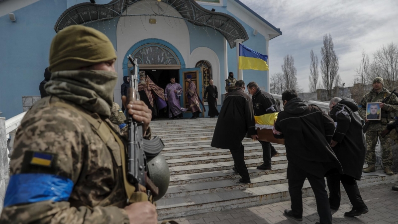 Compañeros de un soldado fallecido le rinden homenaje este domingo 27 de marzo de 2022 en el cementerio de Yuzhne (Ucrania).