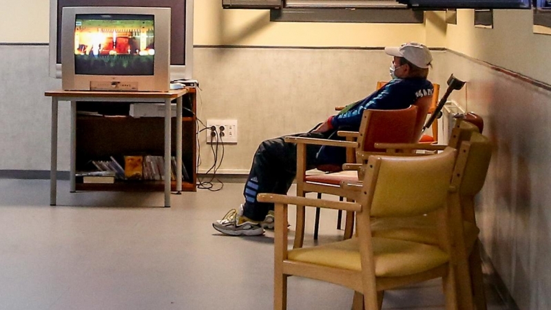 Un hombre ve la de televisión en una sala  de un albergue para personas sin hogar, en Madrid. E.P./Ricardo Rubio