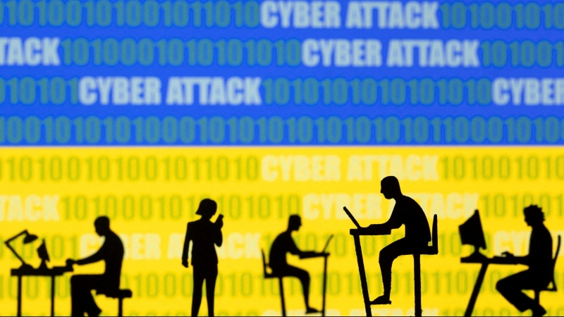 Figuras con ordenadores y móviles frente a las palabras 'ataque cibernético', códigos binarios y la bandera ucraniana.