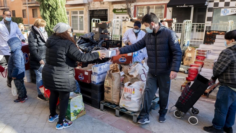 7/01/2022-Personas en riesgo de exclusión acuden a recoger alimentos de la Fundación Madrina, en la plaza de San Amaro, el 7 de enero, en Madrid