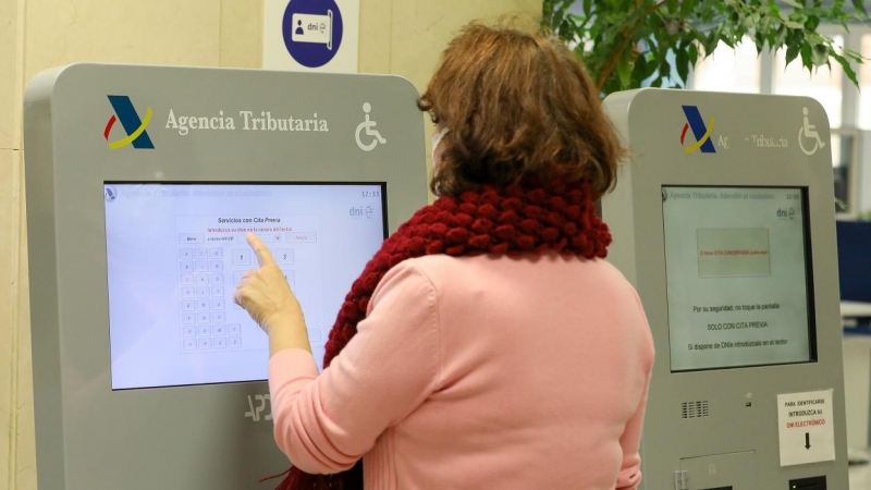 Una mujer recoge su turno en una oficina de la Agencia Tributaria. E.P./Marta Fernández