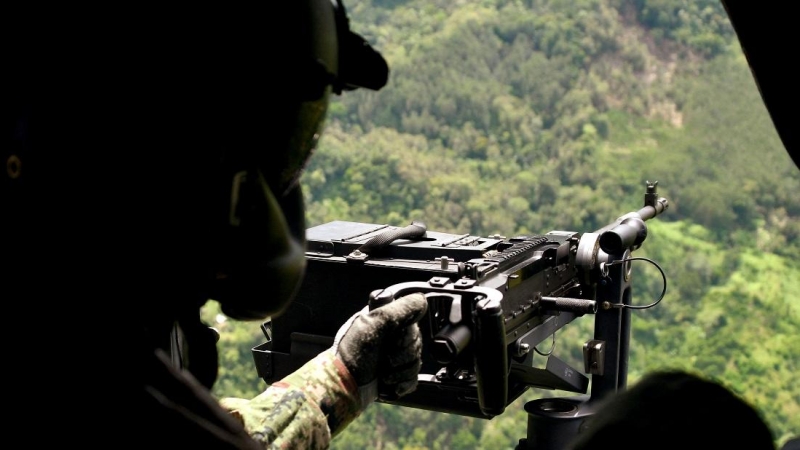 Un soldado permanece en posición en un helicóptero que sobrevuela la zona donde fuerzas militares -en la víspera- capturaron al narcotraficante Dairo Antonio Úsuga, alias Otoniel, cerca de Carepa, departamento de Antioquia, Colombia, el 24 de octubre de 2