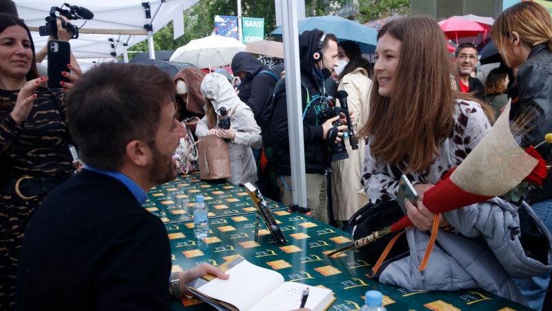 El periodista Toni Cruanyes signa un llibre mentre conversa amb una lectora.
