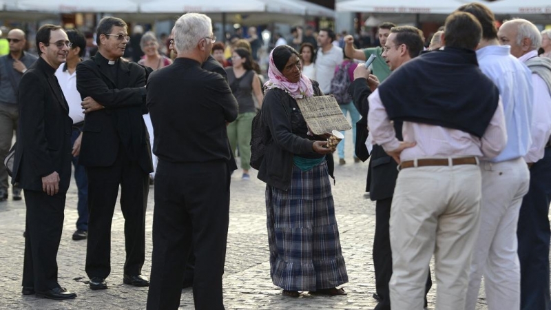 Una mujer suplica a los sacerdotes católicos en la Plaza Mayor de Madrid el 26 de septiembre de 2014.