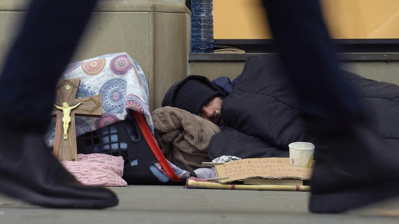 Un vagabundo duerme en la acera de la calle Passeig de Gracia en Barcelona el 29 de enero de 2019.