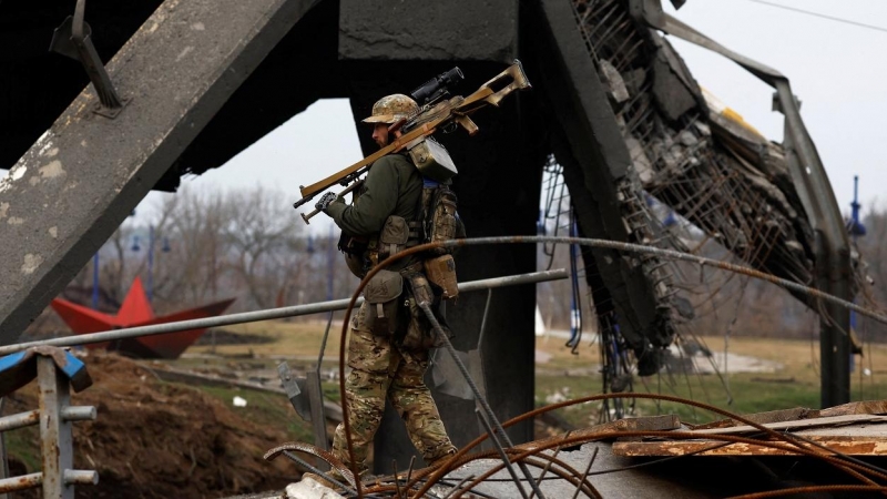 Un militar ucraniano lleva su arma bajo un puente dañado, en medio de la invasión rusa de Ucrania, en Irpin. REUTERS/Zohra Bensemra