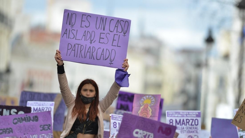 Una joven con un cartel en una manifestación estudiantil feminista por el 8M, Día Internacional de la Mujer, en la Puerta del Sol, a 8 de marzo de 2022, en Madrid