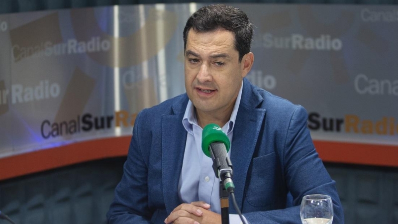 El presidente de la Junta de Andalucía, Juanma Moreno (c), es entrevistado por el periodista Jesús Vigorra. En la sede de Canal Sur Radio, en el Pabellón de Andalucía de la Isla de la Cartuja.