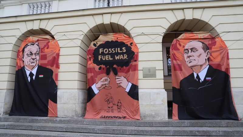 Varsovia (Polonia), 25/05/2022.- Pancartas que muestran al primer ministro húngaro, Viktor Orban (L), al presidente ruso, Vladimir Putin (R), y al lema 'Guerra de combustibles fósiles' durante una protesta de Greenpeace exigiendo un boicot al petróleo rus