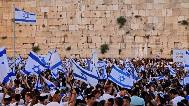 Los manifestantes se reúnen con banderas israelíes en el Muro Occidental en la ciudad vieja de Jerusalén el 29 de mayo de 2022, durante la 'marcha de banderas' israelí para conmemorar el 'Día de Jerusalén'.