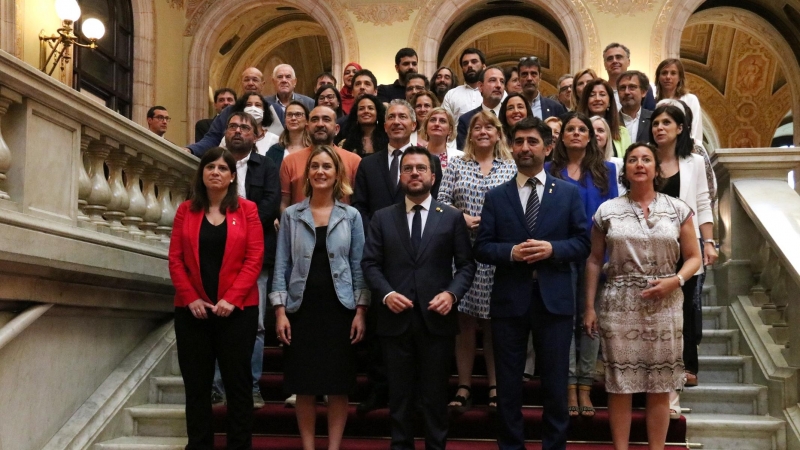 El president del Govern, Pere Aragonès, amb més representants de l'executiu, i dels grups parlamentaris de PSC-Units, ERC, Junts i En Comú Podem, a les escales del Parlament després d'aprovar la llei del català per respondre la sentència del 25%.