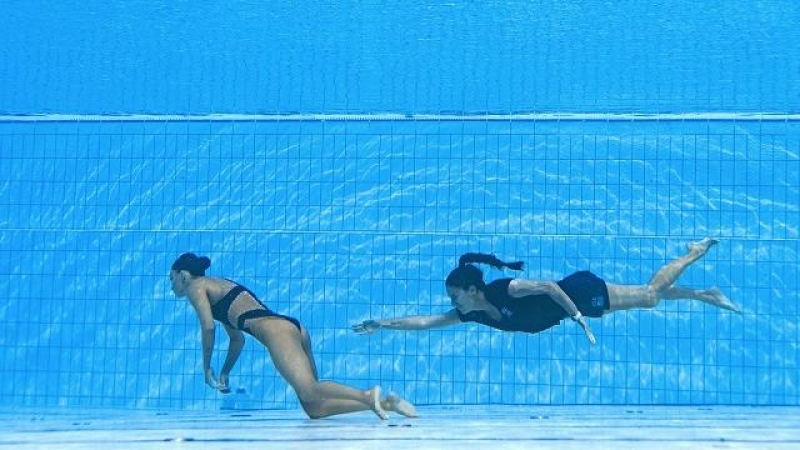 Un miembro del Equipo de EE. UU. (R) nada para recuperar a Anita Alvarez (L) de EE. UU., Del fondo de la piscina durante un incidente en las finales de natación artística libre en solitario de mujeres, durante el Campeonato Mundial Acuático de Budapest 20