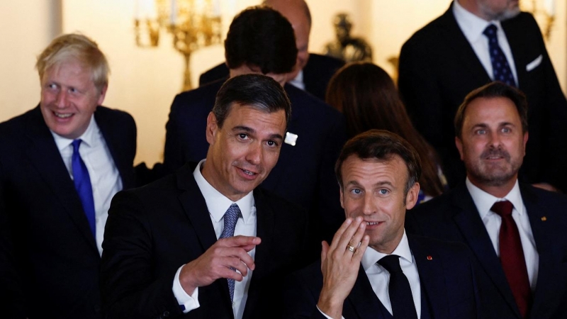 El presidente del Gobierno, Pedro Sánchez, con el presidente francés, Emmanuel Macron, mientras posan para la foto de familia con el rey Felipe, la reina Letizia y los líderes de la OTAN, antes de la cena de gala en el Palacio Real de Madrid. REUTERS/Susa