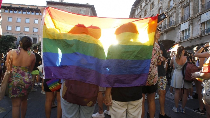 Dos personas se tapan con una bandera durante una manifestación por el Orgullo LGTBI, a 28 de junio de 2022, en Palma de Mallorca, Baleares (España).