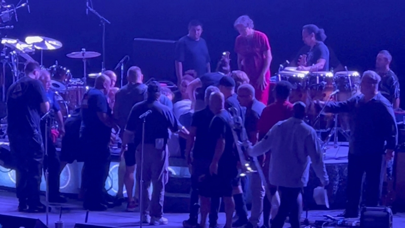 Personal médico y otras personas atienden al guitarrista Carlos Santana después de que se desmayó mientras actuaba en el escenario durante un espectáculo en el Pine Knob Music Theatre en Clarkson, Michigan, EEUU