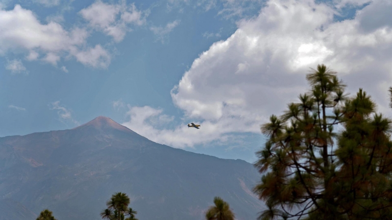 Un avión pasa junto al pico de El Teide en uno de sus viajes a la costa para abastecerse de agua durante las labores de extinción del incendio que afecta al norte de la isla de Tenerife, este viernes.