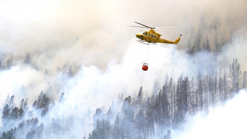 Un helicóptero contra incendios descarga agua sobre un incendio forestal en Tenerife Norte, a 23 de julio de 2022