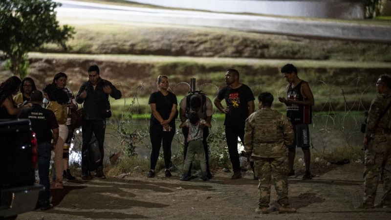 Los migrantes son detenidos por tropas de la Patrulla Fronteriza y la Guardia Nacional de EE. UU. en Eagle Pass, Texas, cerca de la frontera con México, el 30 de junio de 2022.