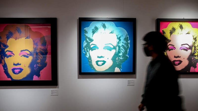 Un visitante pasa junta a varios retratos de Marilyn Monroe del artista estadounidense Andy Warhol en una exposición en febrero de 2022 en Madrid. E.P./ Ricardo Rubio