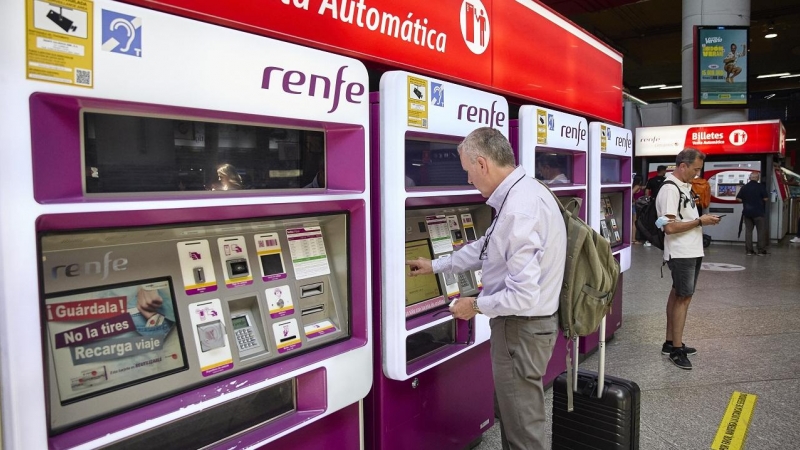 Una persona en una de las máquinas de venta de billetes en la estación Madrid-Atocha Cercanías, a 8 de agosto de 2022, en Madrid (España).