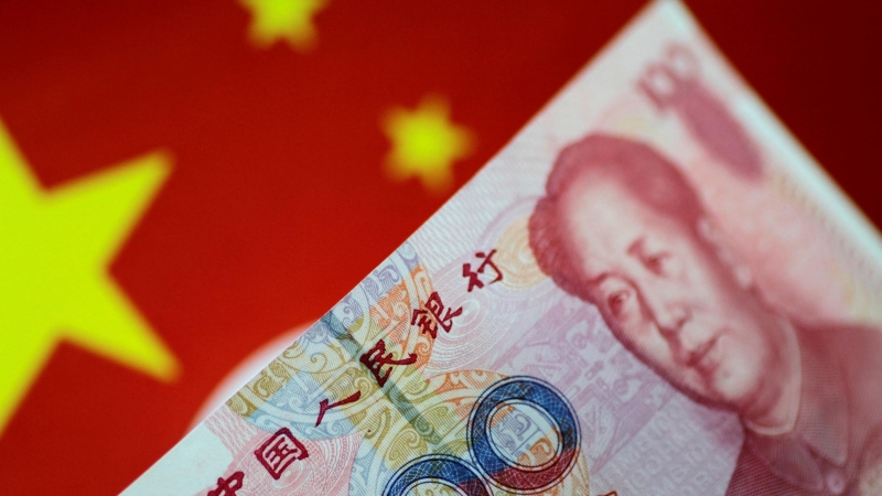 El yuan, moneda del país, bajo la bandera de China.