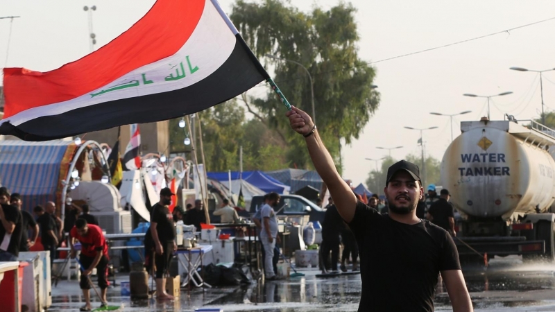Un seguidor del clérigo Muqtada al Sadr ondea la bandera de Irak en una protesta del 8 de agosto.