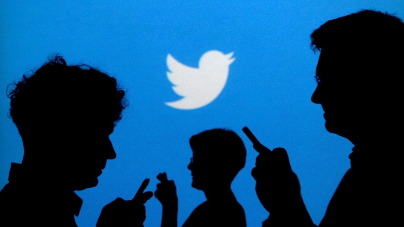27/09/2013-Personas que sostienen teléfonos móviles forman su silueta contra un fondo proyectado con el logo de Twitter en esta foto de ilustración tomada el 27 de septiembre de 2013