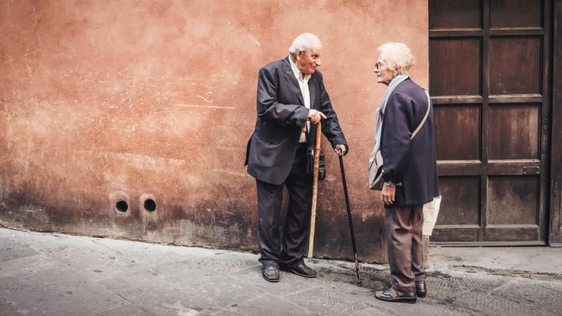 Dos personas mayores hablan en la calle, en una imagen de archivo