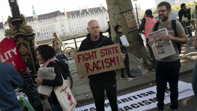 Un asistente a la protesta tras la muerte de Chris Kaba, sostiene una pancarta que insta a combatir 'el racismo del Estado' frente a las oficinas de la policía de Scotland Yard en Londres