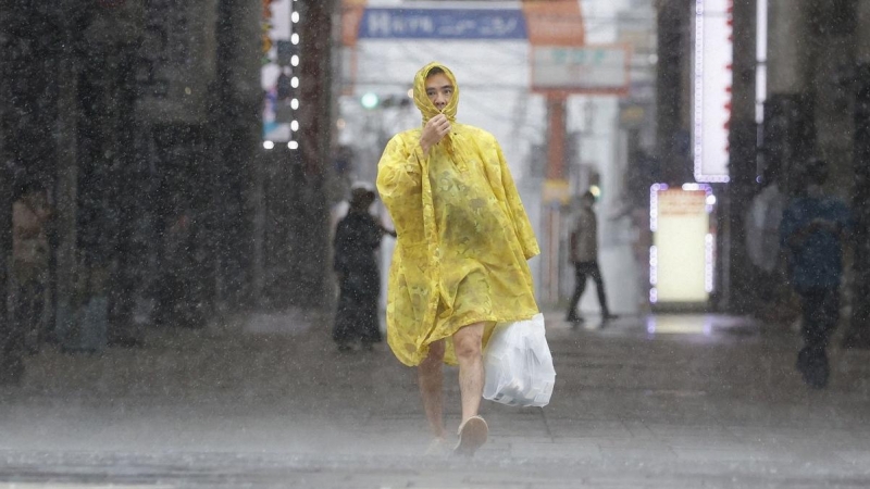 Un hombre camina por la calle bajo fuertes lluvias y vientos causados ​​por el tifón Nanmadol en Kagoshima, en la isla principal más al sur de Japón.