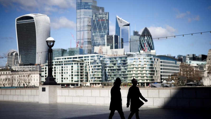 Dos personas pasean al lado del Támesis en Londres, con los edificios de la City, el distrito financiero, al fondo. REUTERS/Henry Nicholls