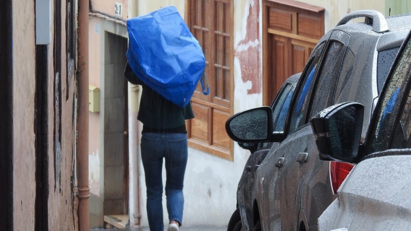 Una persona se protege de la lluvia con una bolsa de plástico durante una tormenta registrada en La Orotava, en Tenerife, este sábado.