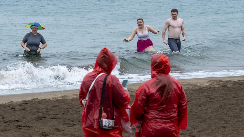 Unos turistas se dan un baño en Puerto del Carmen, municipio de Tías.