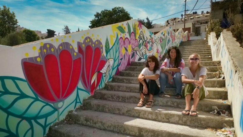 Las muralistas Irene Bofill, Iris Serrano y Julieta Xlf, junto a uno de su murales.