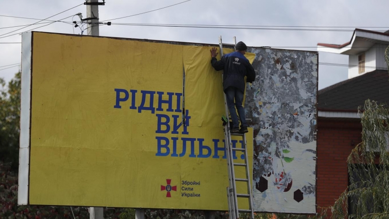 Un hombre colocauUn cartel que dice 'Ciudadanos, sois libres' en la ciudad recién liberada de Kupiansk, al este de Kharkiv, Ucrania, este lunes 3 de octubre de 2022.