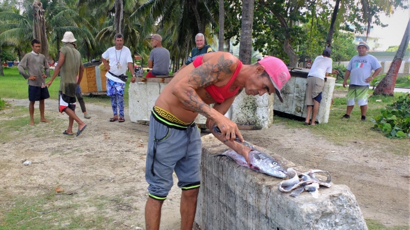 Fotografía de un pescador cubano manipulando uno de sus pescados.