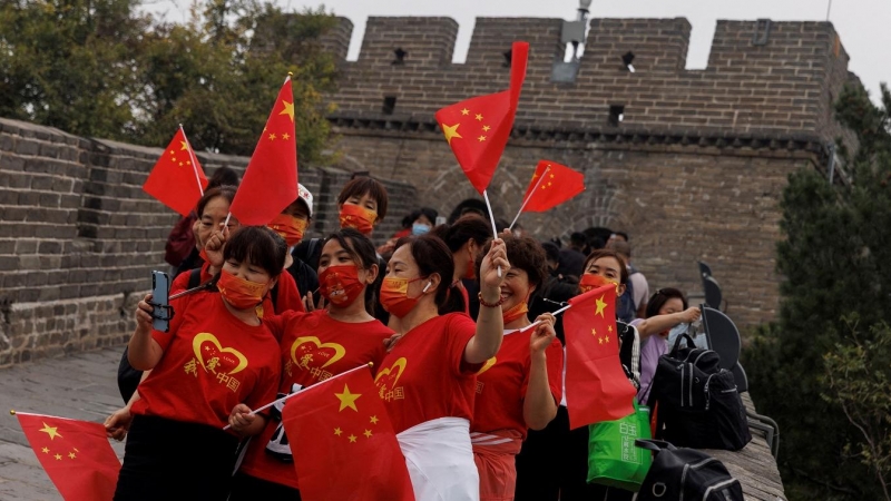 Varias personas en la Gran Muralla con banderas de China, el día de la Fiesta Nacional, el pasado 1 de octubre. REUTERS/Thomas Peter
