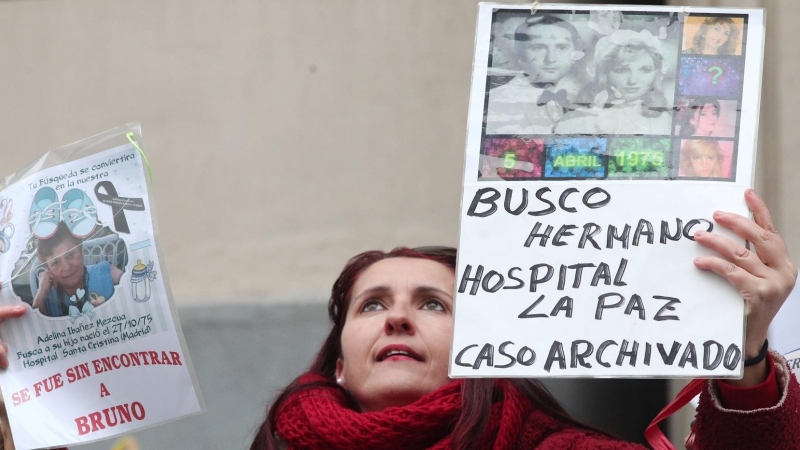 Una mujer sujeta un cartel en que se lee 'Busco hermano Hospital La Paz caso archivado', en la concentración estatal de bebés robados frente a la Fiscalia General del Estado, Madrid (España), a 27 de enero de 2020.